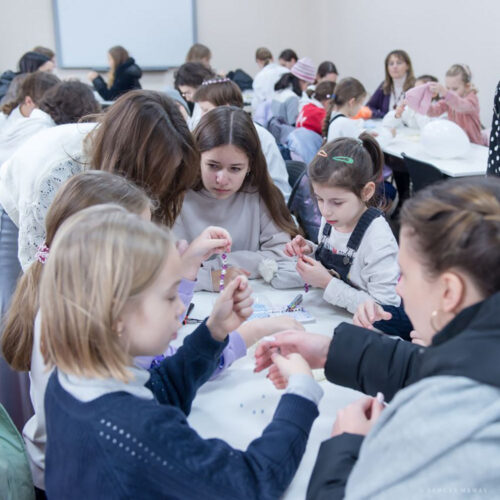 Children making bracelets together.