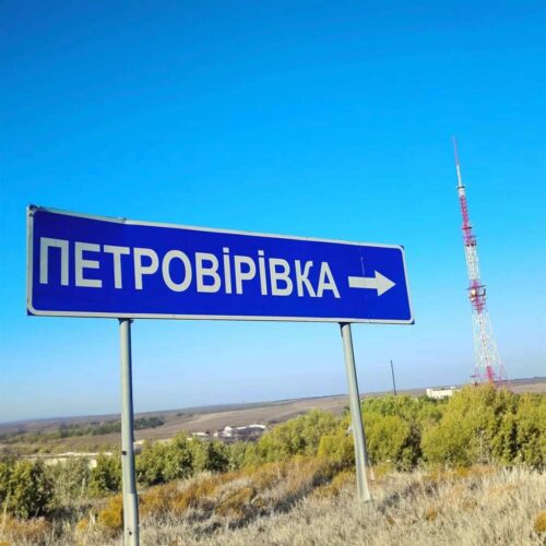 A blue sign with an arrow next to a cell tower.