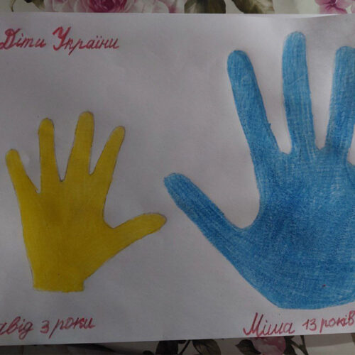 A children's drawing of two handprints in blue and yellow.