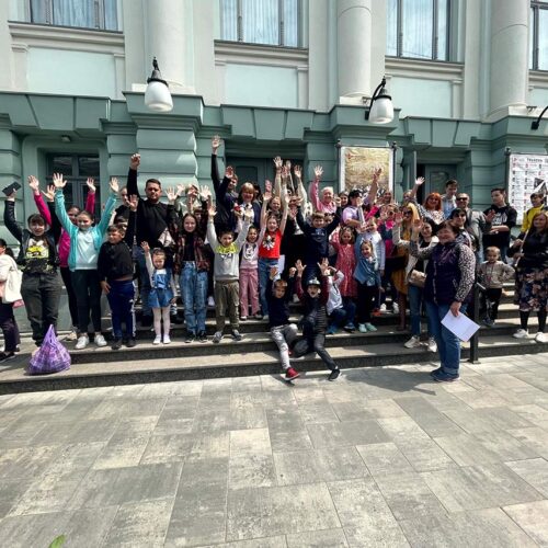 Group of people cheering by building.