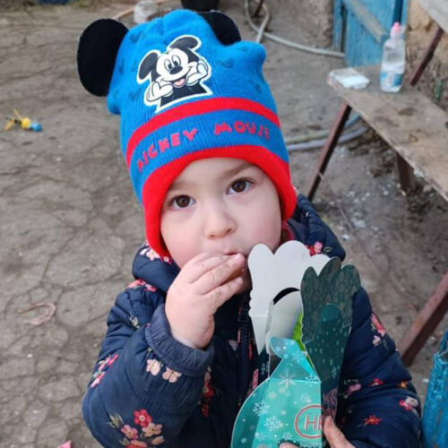 Little child holding paper box and eating.