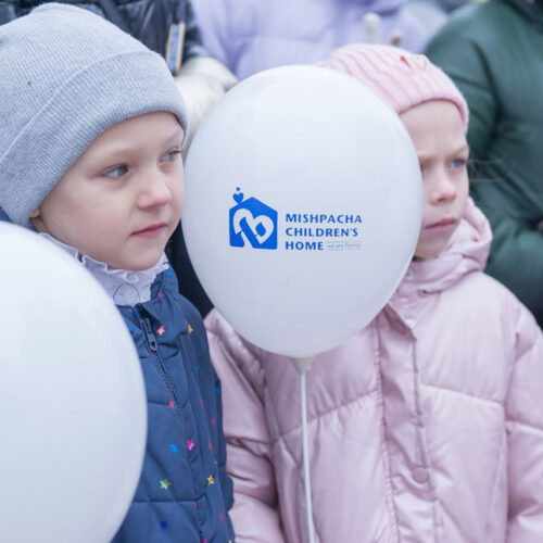 Two children holding balloon.