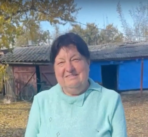 Woman in a blue shirt smiling.